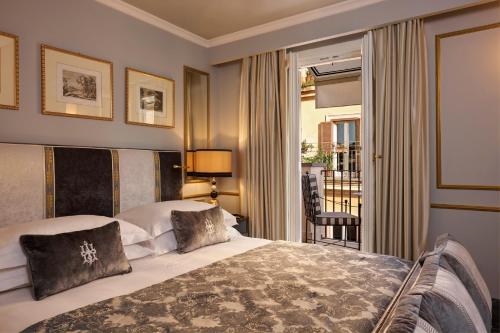 a hotel room with a bed and a balcony at Hotel d’Inghilterra Roma – Starhotels Collezione in Rome