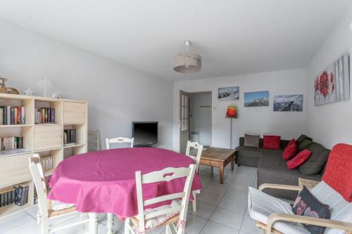 a living room with a table and a couch at Appart Tout Confort in Guillestre