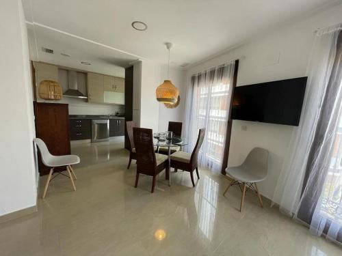 Una cocina y un comedor con mesa y sillas. en Piso Centro Elche junto Basílica, en Elche