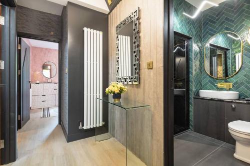 uma casa de banho com um WC, um lavatório e um espelho. em 1LSR - High-End Luxury 2 Bed Designer Apartment em Londres
