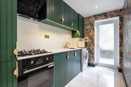 uma cozinha com armários verdes e um fogão em 1LSR - High-End Luxury 2 Bed Designer Apartment em Londres