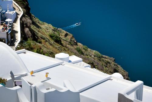 a view of the blue ocean from the side of a cliff at Remvi Suites in Firostefani
