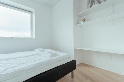 a white room with a bed and a window at Delightful 2 Bedroom Apt - Balcony - Parking in Tórshavn