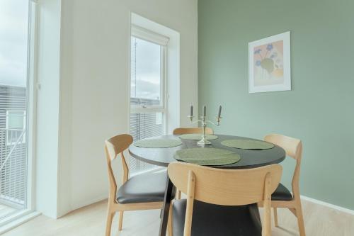 a dining room with a table and chairs at Delightful 2 Bedroom Apt - Balcony - Parking in Tórshavn