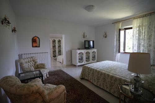 una camera con letto, divano e sedia di Villa Helma Lago Maggiore a Caravate