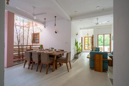 a dining room and living room with a table and chairs at NETS Cowork & Colive in Ahangama