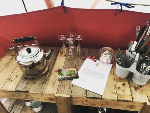 a wooden table with a tea kettle and wine glasses at Tipi Adventure in Walford