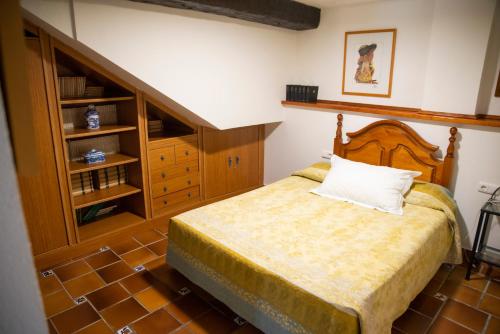 a bedroom with a bed and a wooden cabinet at Casa Armonía in Cenes de la Vega