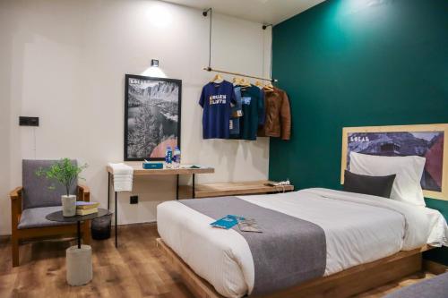ein Schlafzimmer mit einem Bett und einer grünen Wand in der Unterkunft LOKAL Rooms x Skardu (Mountain View) in Skardu