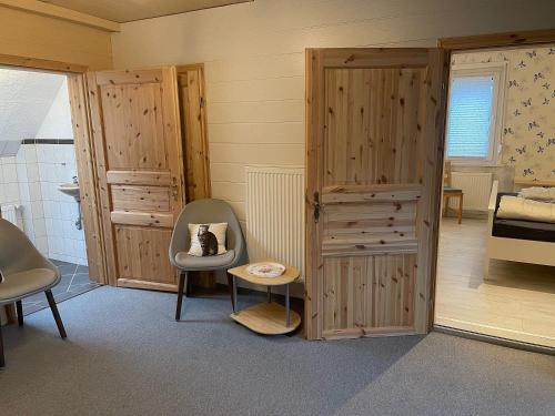 Zimmer mit einer Tür, einem Stuhl und einem Bett in der Unterkunft Bienenhof Illers in Wieda