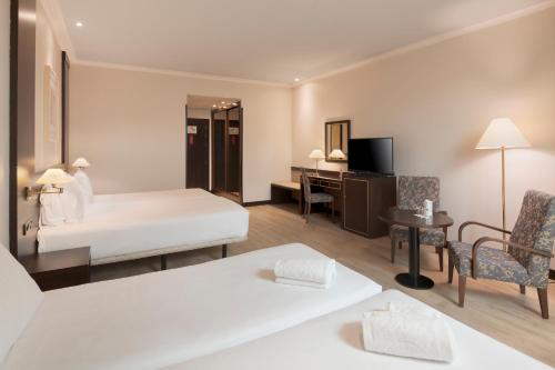 a hotel room with a bed and a desk at Exe Oviedo Centro in Oviedo