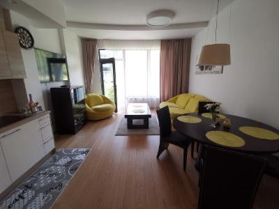 a kitchen and living room with a table and a dining room at Vita Apartment in Druskininkai