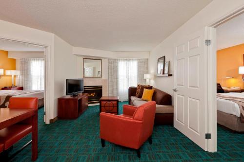 a hotel room with a bed and a living room at Residence Inn Indianapolis Fishers in Fishers