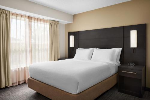 a bedroom with a large bed and a large window at Residence Inn Indianapolis Northwest in Indianapolis