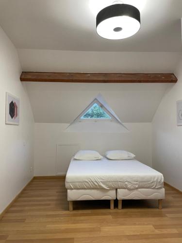 a bedroom with a bed and a window at Sweethome – La Jacqueminière in Courtenay