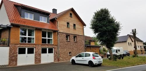 een witte auto geparkeerd voor een huis bij Alte Scheune in Mossautal