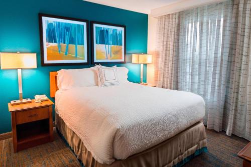 a hotel room with a large bed and two lamps at Residence Inn Huntsville in Huntsville