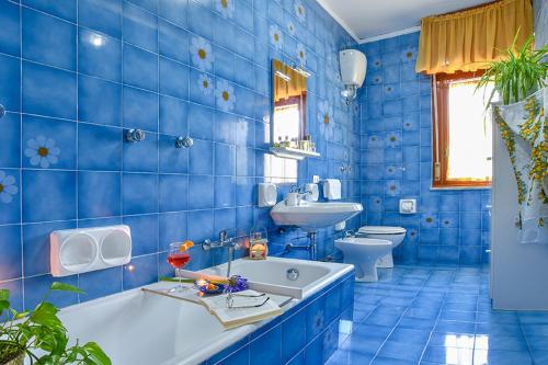 La salle de bains bleue est pourvue d'une baignoire et d'un lavabo. dans l'établissement Villa Li Campi, à Massa Lubrense