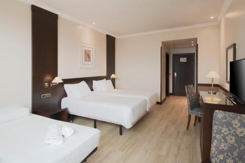 a hotel room with two beds and a television at Exe Oviedo Centro in Oviedo