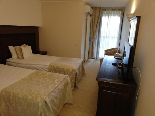 pokój hotelowy z 2 łóżkami i telewizorem z płaskim ekranem w obiekcie Apartament 804- Etaj 8 in incinta Alpin Resort - gazda privata w Braszowie