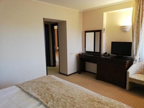 um quarto com uma cama e uma secretária com uma televisão em Apartament 804- Etaj 8 in incinta Alpin Resort - gazda privata em Braşov