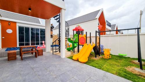 een achtertuin met een speeltuin met een glijbaan bij child shill pool villa in Ban Wang Bot