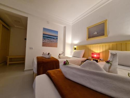 a hotel room with two beds and a couch at Zak Inn in Hurghada