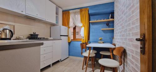 a kitchen with a blue accent wall and a small table at relax in Samtredia