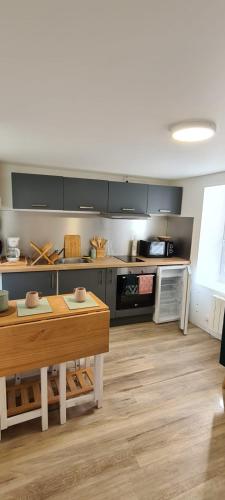 - une cuisine avec une table en bois dans une chambre dans l'établissement Bright little house in Douvres-la-Délivrande, à Douvres-la-Délivrande