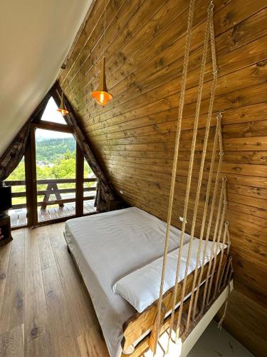 a bed in a room with a wooden wall at Cabana A in Borşa