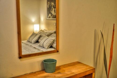 a mirror on a wall with a bed in a room at Iro Suites in Andros