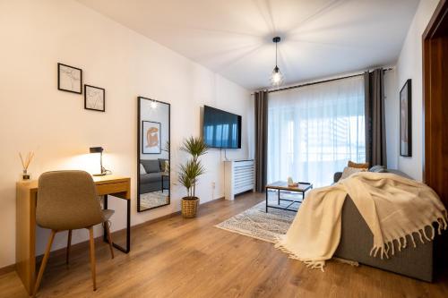Schlafzimmer mit einem Schreibtisch und einem Bett in einem Zimmer in der Unterkunft Lakeview Modern Condo-Tennis, Parking, Balcony in Cluj-Napoca