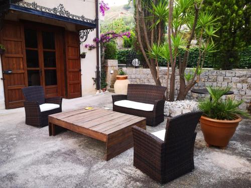 a patio with wicker chairs and a wooden table at Villa Calcerame in Montelepre