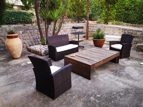 a patio with chairs and a wooden table and a table and chairs at Villa Calcerame in Montelepre