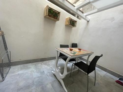 mesa y sillas en una habitación con ventana en Borgata di Levante, en Siracusa