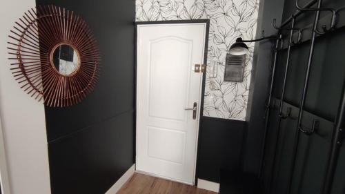 pasillo con puerta blanca y espejo en Le Tréville Grand Studio Cosy 32M2, en Rochefort