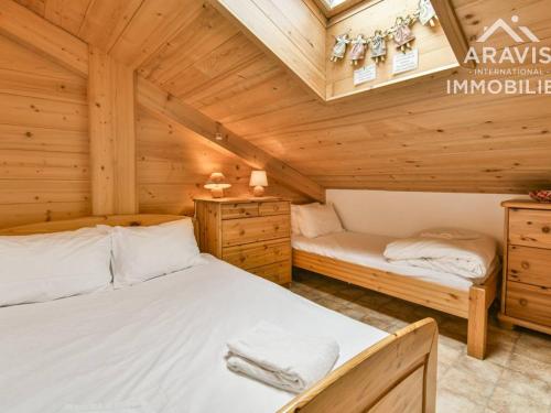 1 dormitorio con 2 camas en una cabaña de madera en Appartement Le Grand-Bornand, 4 pièces, 8 personnes - FR-1-391-92, en Le Grand-Bornand