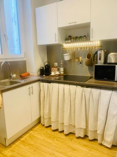 une cuisine avec des armoires blanches et un évier dans l'établissement Un havre de paix marseillais, à Marseille