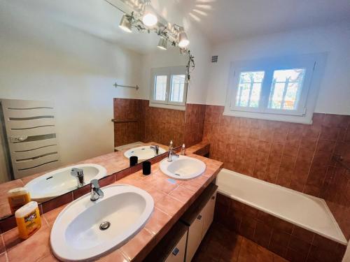 a bathroom with two sinks and a bath tub at Escale Douceur d'Estérel in Saint-Raphaël