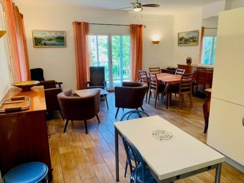 un salon avec des tables et des chaises ainsi qu'une salle à manger dans l'établissement Maison F3 avec parking, clim et wifi - 4 pers - FR-1-703-18, à Amélie-les-Bains-Palalda