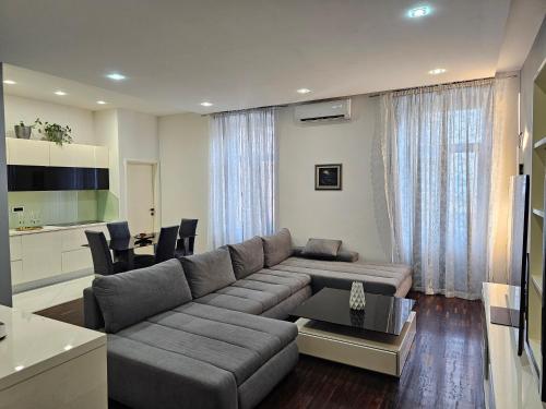 a living room with a large couch and a kitchen at Azzuro apartment Self check in in Rijeka