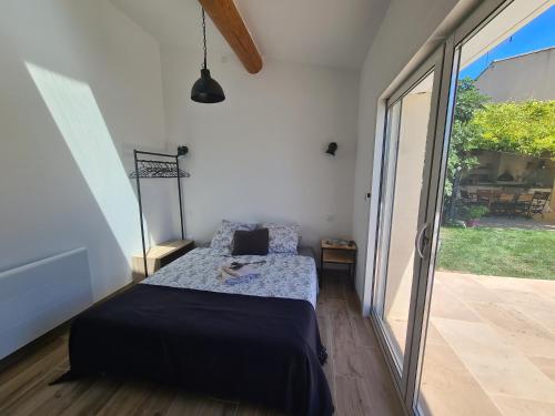 une chambre avec un lit et une porte coulissante en verre dans l'établissement Chambre d'hôte Villelaure, à Villelaure