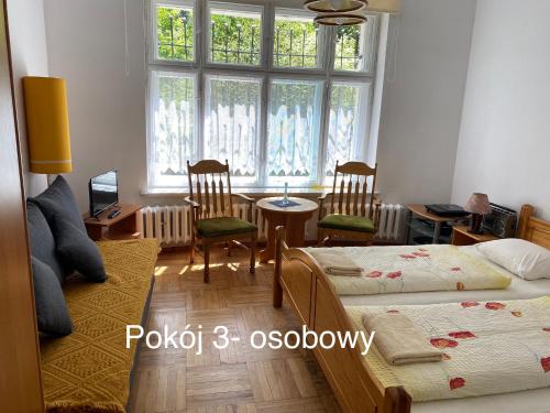 ソスノフカにあるApartamenty Mariaのベッドルーム1室(ベッド2台、テーブル、椅子付)