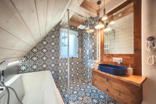 a bathroom with a shower with a tub and a sink at Osada Gąsienica Centrum Zakopane in Zakopane