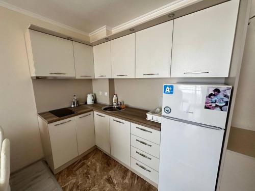 a kitchen with white cabinets and a white refrigerator at SEA-VIEW APARTMENT in VILLA SARDINIA SVETI VLAS in Sveti Vlas