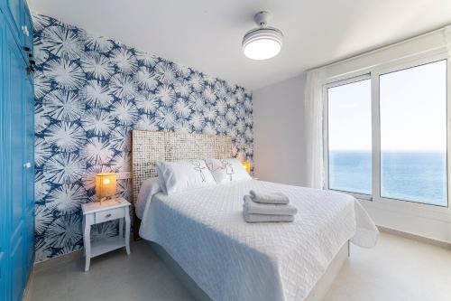 a bedroom with a bed with a blue and white wallpaper at Los acantilados in Almería