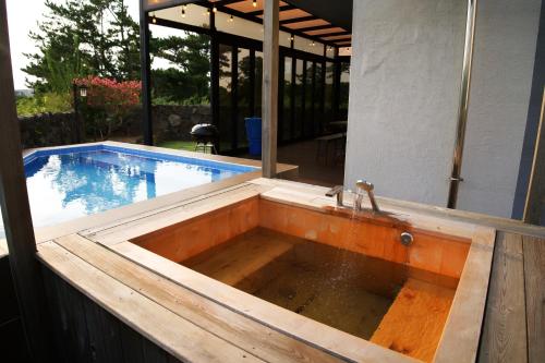 a pool with a sink and a swimming pool at Hyeopjae MoonBeam in Jeju