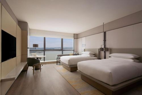 a hotel room with two beds and a large window at Shantou Marriott Hotel in Shantou