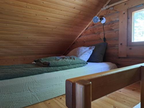 1 dormitorio con 2 camas en una cabaña de madera en Rantamökki Naava, en Hämeenlinna