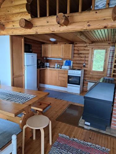 a large kitchen with a table and a refrigerator at Rantamökki Naava in Hämeenlinna